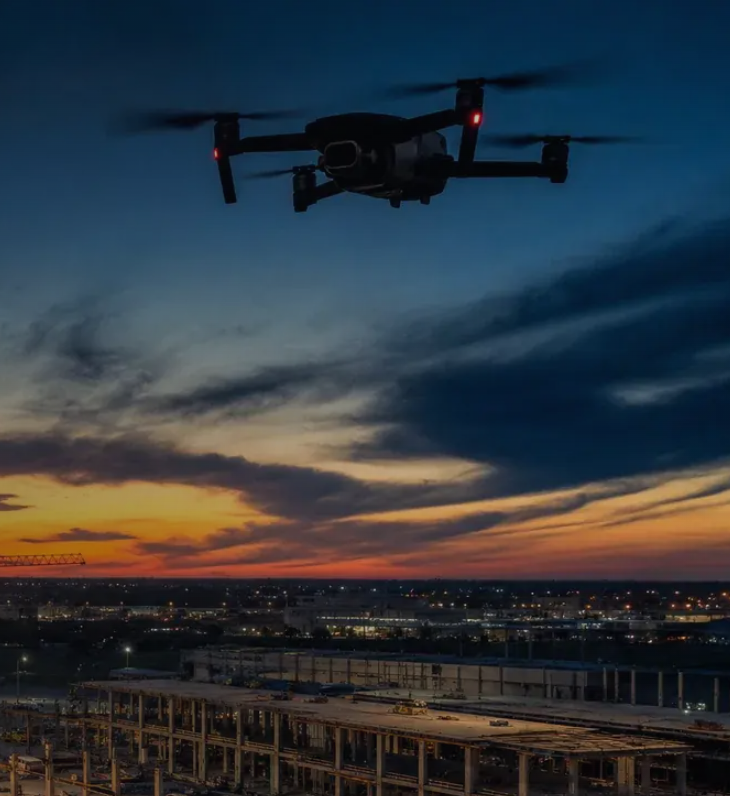 Drone flying over a construction site at sunset